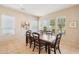 Well-lit dining room with a wooden table, chairs, and views of the community landscape at 27320 N 127Th Dr, Peoria, AZ 85383