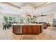 Kitchen island provides seating and features pendant lighting, with views into the living and dining areas at 27320 N 127Th Dr, Peoria, AZ 85383