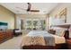 Spacious main bedroom with large windows providing views of the beautiful outdoor landscape and a ceiling fan at 27320 N 127Th Dr, Peoria, AZ 85383