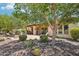 Inviting covered patio with outdoor kitchen, fire pit, and seating area surrounded by lush landscaping at 27320 N 127Th Dr, Peoria, AZ 85383