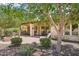 Inviting covered patio with outdoor kitchen, fire pit, and seating area surrounded by lush landscaping at 27320 N 127Th Dr, Peoria, AZ 85383