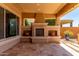 Covered patio with tile flooring and a cozy stone fireplace at 27537 W Yukon Dr, Buckeye, AZ 85396