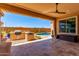 Relaxing covered patio area with built-in BBQ and access to the pool and low-maintenance desert landscaping at 27537 W Yukon Dr, Buckeye, AZ 85396
