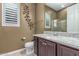 Bathroom with granite countertops, wood cabinets, tile flooring, shutters, and a walk-in shower at 27537 W Yukon Dr, Buckeye, AZ 85396