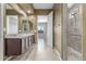 Bathroom featuring a double sink granite vanity, and a walk-in shower with decorative tile at 27537 W Yukon Dr, Buckeye, AZ 85396