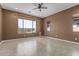 A neutral primary bedroom with large windows providing ample natural light and views of the landscaped backyard at 27537 W Yukon Dr, Buckeye, AZ 85396