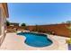 Backyard kidney shaped pool features desert landscaping, custom hardscape and blue skies at 27537 W Yukon Dr, Buckeye, AZ 85396