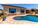 Backyard kidney shaped pool with custom hardscape, patio, and exterior view at 27537 W Yukon Dr, Buckeye, AZ 85396