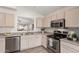 Functional kitchen features stainless steel appliances, bright cabinets, and an open pass-through to the dining area at 280 W Sheffield Ave, Gilbert, AZ 85233