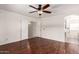 Open bedroom floorplan boasts hardwood flooring, ceiling fan, and adjacent view into the primary bathroom at 280 W Sheffield Ave, Gilbert, AZ 85233