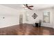 Empty bedroom boasts hardwood flooring, ceiling fan, and adjacent view into the primary bathroom at 280 W Sheffield Ave, Gilbert, AZ 85233