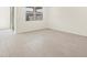 Empty bedroom showcasing wood-look floors, natural light, and a view through a large window at 37139 W Prado St, Maricopa, AZ 85138