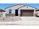 Charming single-story home featuring a brown two car garage and low maintenance desert landscaping at 37139 W Prado St, Maricopa, AZ 85138