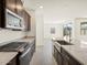 Spacious kitchen featuring stainless appliances, dark cabinets, and stone countertops with an island at 37139 W Prado St, Maricopa, AZ 85138