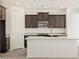 Kitchen featuring an island with granite countertops, stainless appliances, and dark wood cabinets at 37139 W Prado St, Maricopa, AZ 85138