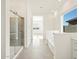 Bright bathroom featuring a glass shower, white cabinets, and a large window offering natural light at 37154 W La Paz St, Maricopa, AZ 85138