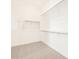 Walk-in closet with carpet flooring and open shelving/hanging rods for ample storage space at 37154 W La Paz St, Maricopa, AZ 85138