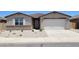 Charming single-story home featuring a stucco exterior, stone accents, and a two-car garage at 37154 W La Paz St, Maricopa, AZ 85138