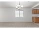 Cozy dining area with chandelier lighting, carpet flooring, and a window view to the front yard at 3728 W Fremont Rd, Phoenix, AZ 85041