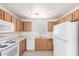 Efficient kitchen featuring white appliances, warm wood cabinets, and plenty of counter space at 3728 W Fremont Rd, Phoenix, AZ 85041