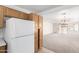 Bright living room featuring a refrigerator and open floor plan with neutral carpeting at 3728 W Fremont Rd, Phoenix, AZ 85041