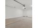 Spacious two car garage with concrete flooring and white walls, providing ample space for vehicles and storage at 37385 W San Sisto Ave, Maricopa, AZ 85138