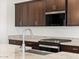 Close up of kitchen with granite countertops, stainless steel sink, stove, and Whirlpool microwave at 37385 W San Sisto Ave, Maricopa, AZ 85138