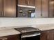 Close up of stainless steel stove and Whirlpool microwave with dark wood cabinets and granite countertops at 37385 W San Sisto Ave, Maricopa, AZ 85138