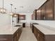 Wide view of kitchen with island, stainless steel appliances, granite countertops and dark wood cabinets at 37385 W San Sisto Ave, Maricopa, AZ 85138