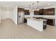 Beautiful kitchen showcasing dark cabinets, stainless steel appliances, and a large center island with granite countertops at 37385 W San Sisto Ave, Maricopa, AZ 85138