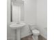 Bathroom with a pedestal sink, toilet, and tile flooring, showcasing a clean and minimalist design at 37399 W San Sisto Ave, Maricopa, AZ 85138