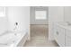 Bright bathroom features a soaking tub, and views of the toilet room and vanity at 37399 W San Sisto Ave, Maricopa, AZ 85138