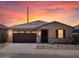 Charming single-story home with a two-car garage, stone accents, neutral paint, and a well-maintained front yard at sunset at 37399 W San Sisto Ave, Maricopa, AZ 85138