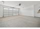 Spacious two car garage with painted walls, concrete flooring, and a garage door with multiple windows along the top at 37399 W San Sisto Ave, Maricopa, AZ 85138