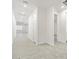 Bright hallway featuring neutral colored tile floor, white walls, doors, and trim throughout at 37399 W San Sisto Ave, Maricopa, AZ 85138
