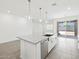 Open kitchen with granite island, pendant lighting, and stainless steel dishwasher at 37399 W San Sisto Ave, Maricopa, AZ 85138