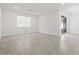 Spacious living room with tile flooring, a large window, and sliding door access at 37399 W San Sisto Ave, Maricopa, AZ 85138