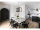 Dining area with modern light fixture, marble table, and view into the kitchen at 3927 E Sheila Ln, Phoenix, AZ 85018