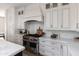 Kitchen features marble countertops and backsplash, professional range, and white cabinetry at 3927 E Sheila Ln, Phoenix, AZ 85018