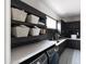 Modern laundry room with dark cabinetry, subway tile backsplash, floating shelves, and updated appliances at 3927 E Sheila Ln, Phoenix, AZ 85018