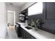 Chic laundry room boasts dark cabinetry, patterned tile flooring, sleek black appliances, and a bright window at 3927 E Sheila Ln, Phoenix, AZ 85018