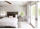 Serene primary bedroom with neutral decor, ceiling fan, and French doors leading to the backyard pool area at 3927 E Sheila Ln, Phoenix, AZ 85018