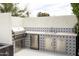 Well-equipped outdoor kitchen features stainless steel appliances, stylish tile, and ample counter space at 3927 E Sheila Ln, Phoenix, AZ 85018