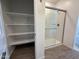 Bathroom closet with shelving and glass-enclosed shower at 4521 S 95Th Dr, Tolleson, AZ 85353