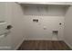 An empty laundry room with connections and space for a washer and dryer and wooden floors at 4521 S 95Th Dr, Tolleson, AZ 85353
