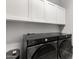 Laundry room with modern black Samsung washer and dryer, and upper cabinets at 461 W Flamingo Dr, Chandler, AZ 85286