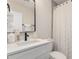 Well-lit bathroom features a vanity with a white countertop, black hardware, and a shower with a decorative curtain at 510 W 14Th St, Tempe, AZ 85281