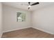 Clean and simple bedroom featuring wood floors, a modern ceiling fan and a window with blinds for natural light at 510 W 14Th St, Tempe, AZ 85281