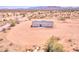 An aerial view of a single-story home with a gray roof and light blue siding surrounded by desert landscape at 52002 W Sotol Rd, Maricopa, AZ 85139