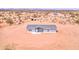 An aerial view of a single-story home with a gray roof and light blue siding situated in a desert landscape at 52002 W Sotol Rd, Maricopa, AZ 85139
